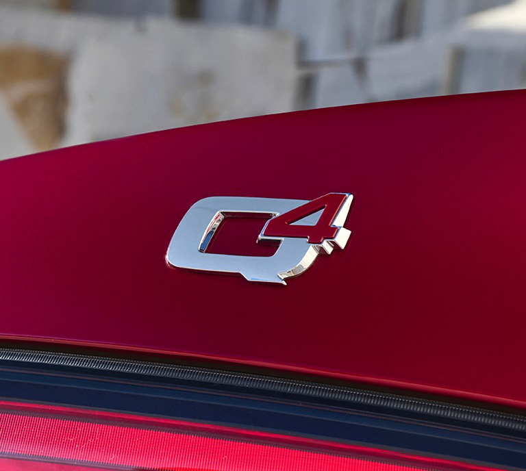 Q4 logo/symbo i sølv og rødt på rød Giulia